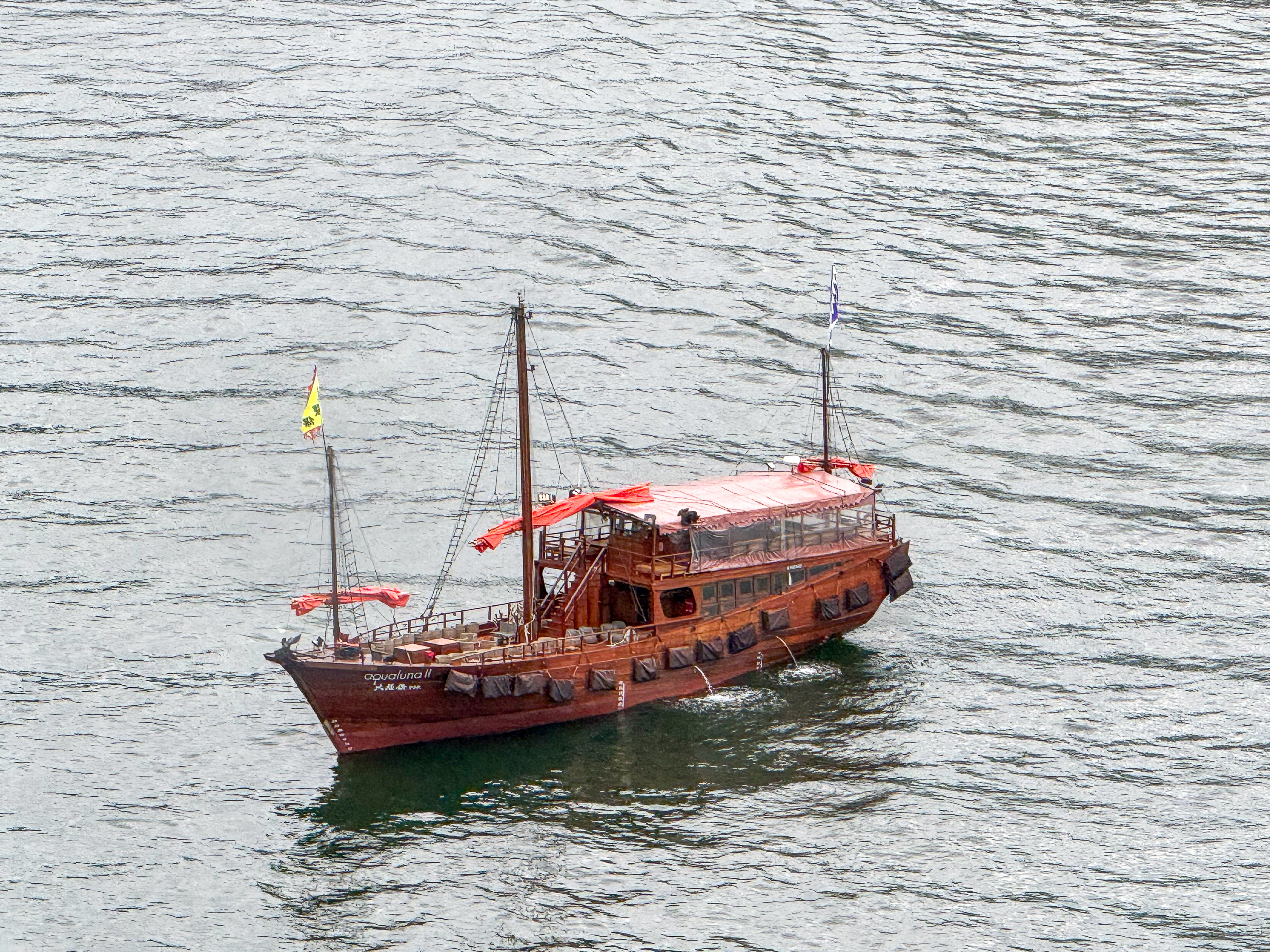 A traditional red Chinese junk sailing across Victoria Harbour