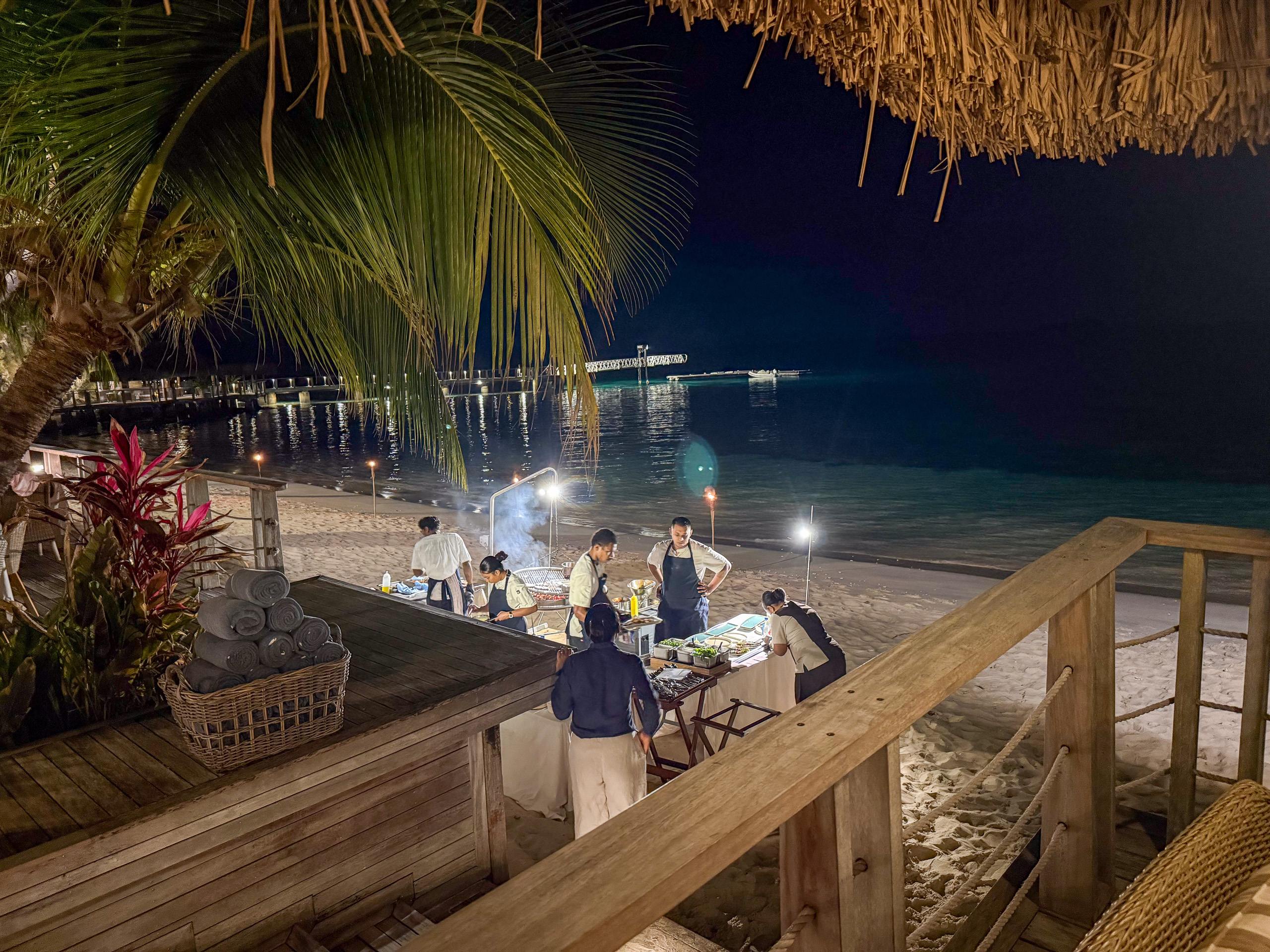 A private table set on the sand for dinner at night on Kokomo