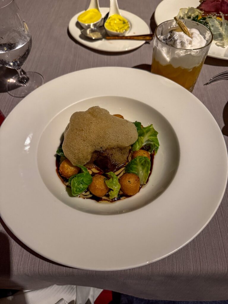 Beef in dark jus with brussels sprout leaves, potato spheres and a crisp golden tuile