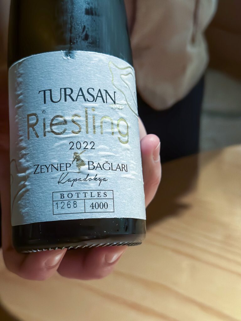 A hand holding a bottle of Turasan Riesling from Zeynep Baglari in Cappadocia