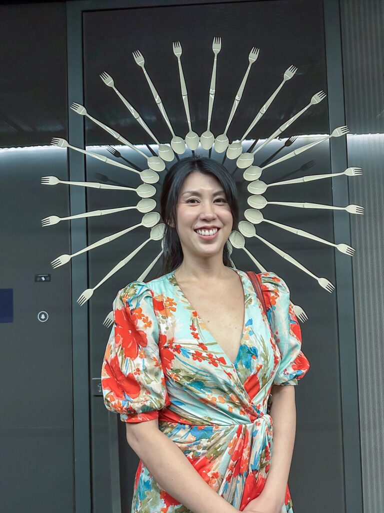 A diner standing in front of the sunburst of forks and spoons mounted beside the entrance