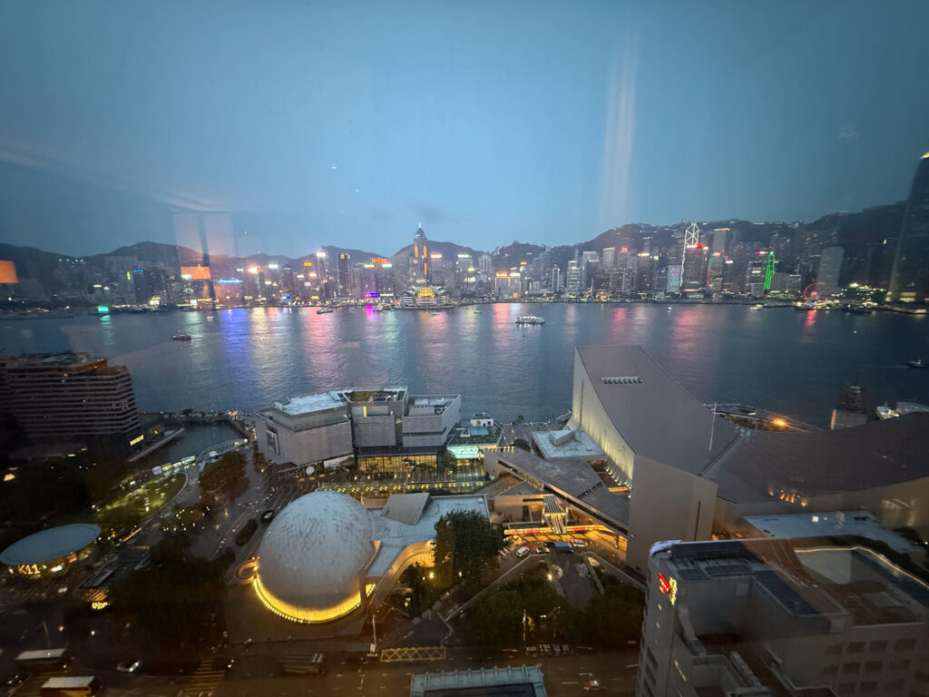 The Hong Kong Island skyline at dusk across Victoria Harbour, seen from The Peninsula