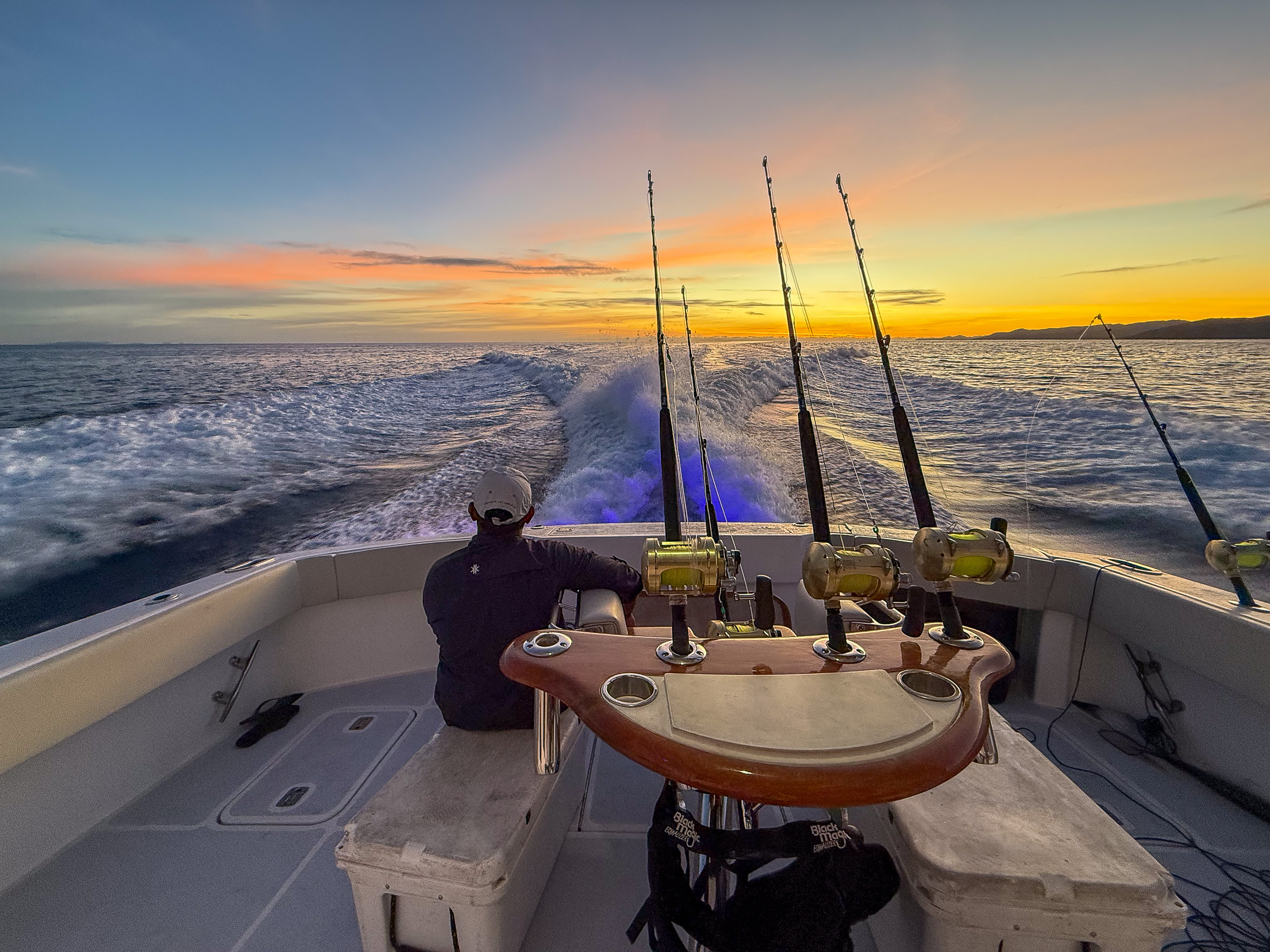 Trolling rods set in the holders as the sun comes up over the wake