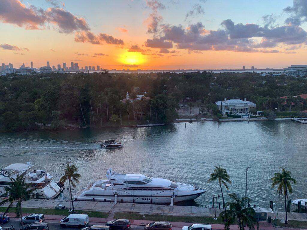 Sunset over Biscayne Bay and the downtown Miami skyline, yachts moored along Indian Creek below