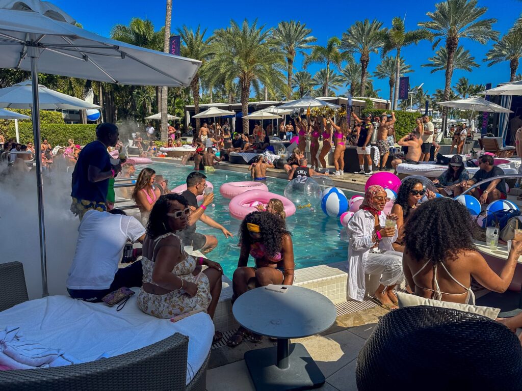 Pool party in full swing with inflatables, daybeds and a misting fan at the pool edge