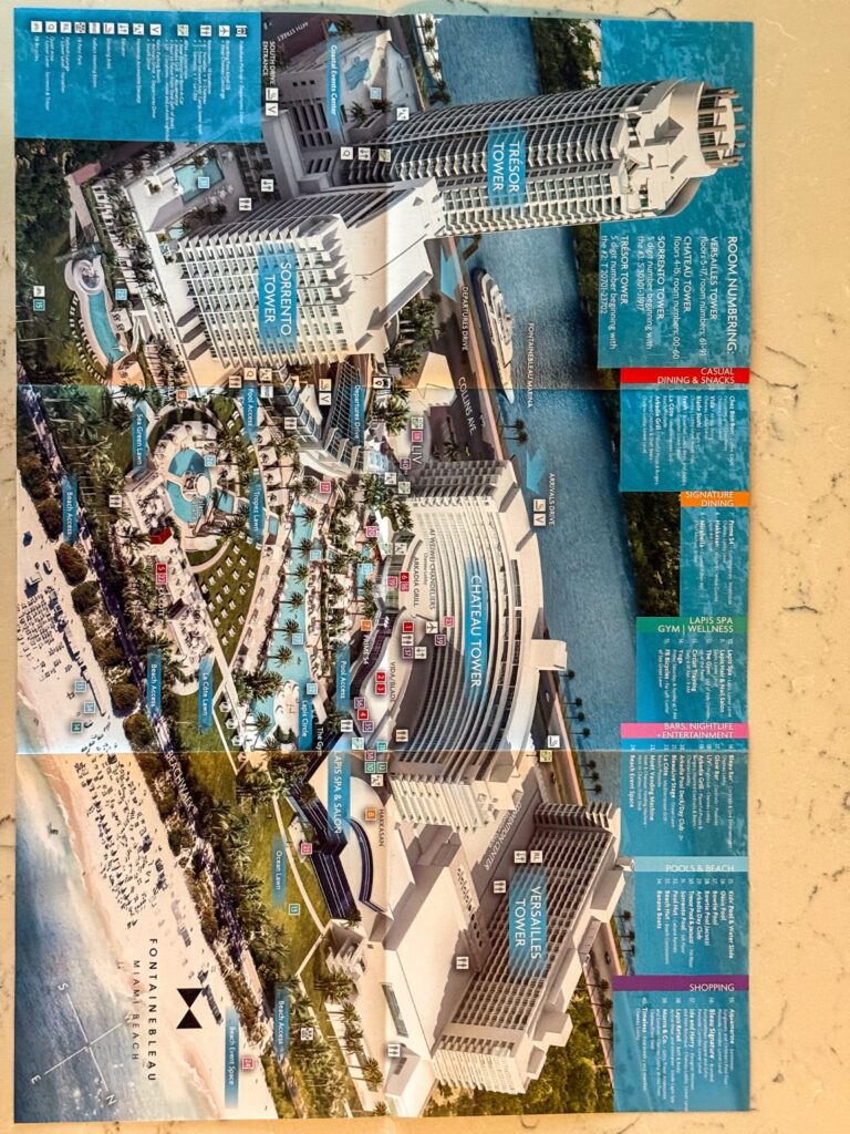 Printed resort map showing the Fontainebleau towers, pools and beach, unfolded on a table