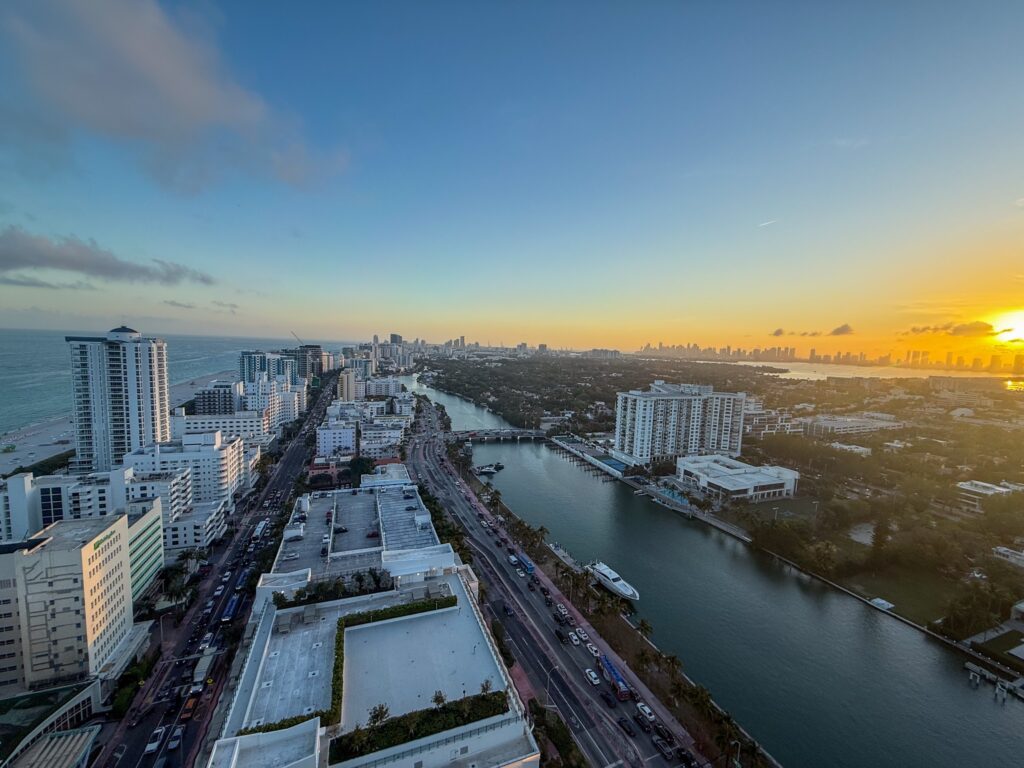 High floor view down Collins Avenue and Indian Creek at sunset