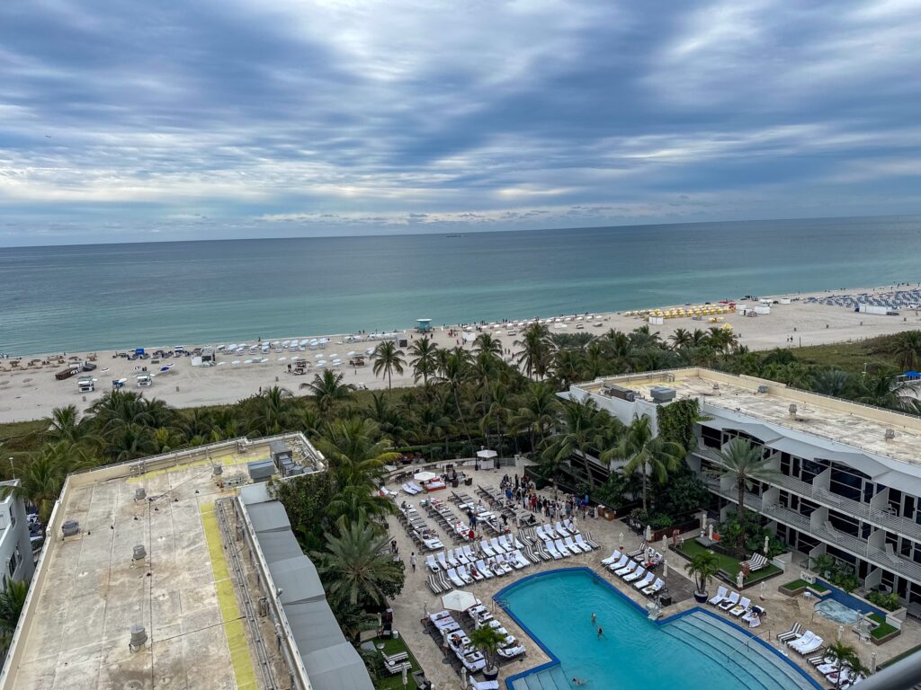 Overhead view of the hotel pool deck and gardens with the beach and ocean beyond