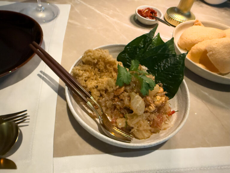 Fried rice with crab served on a betel leaf, prawn crackers and a dish of chilli alongside