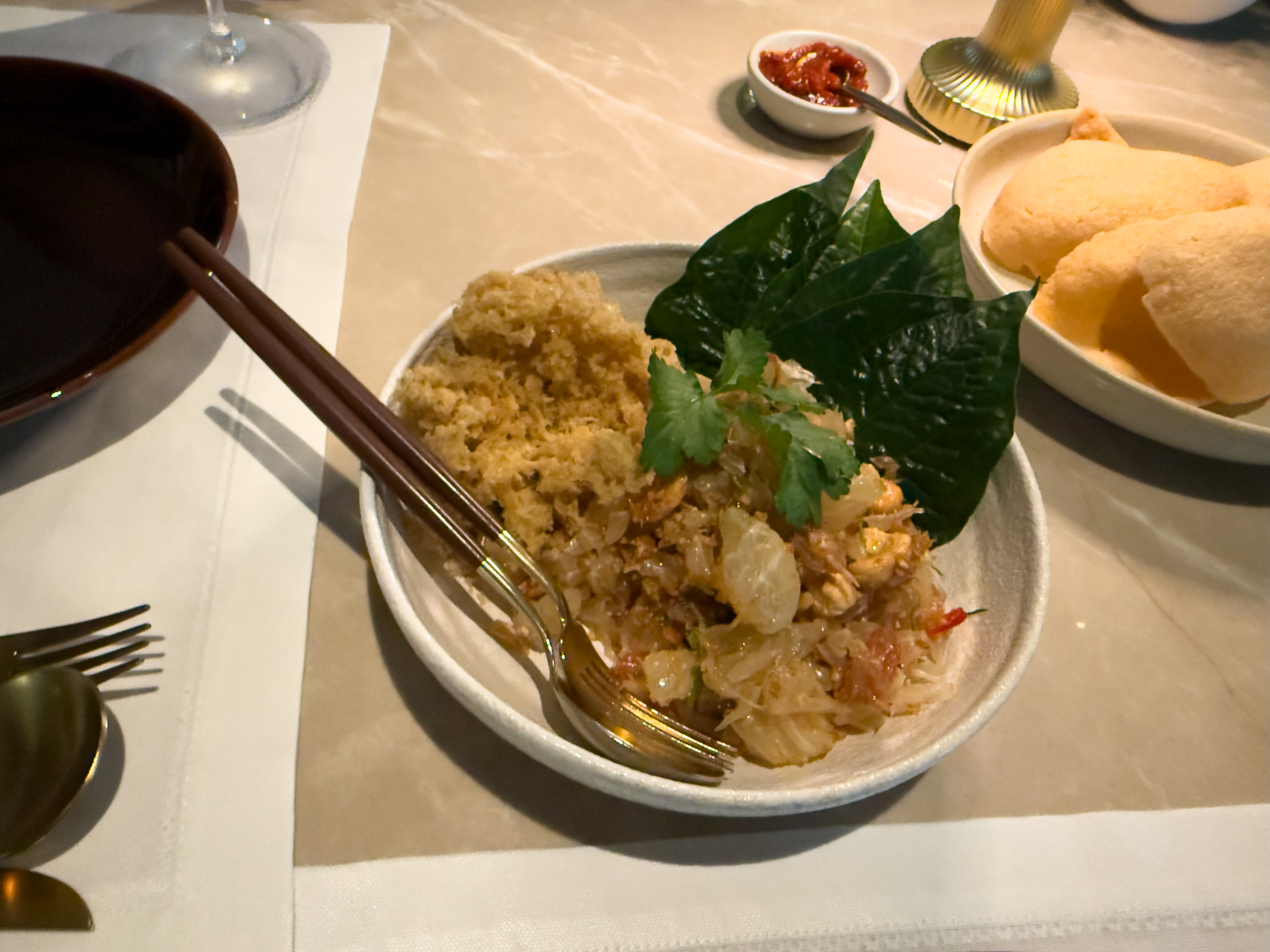 Fried rice with crab served on a betel leaf, prawn crackers and a dish of chilli alongside