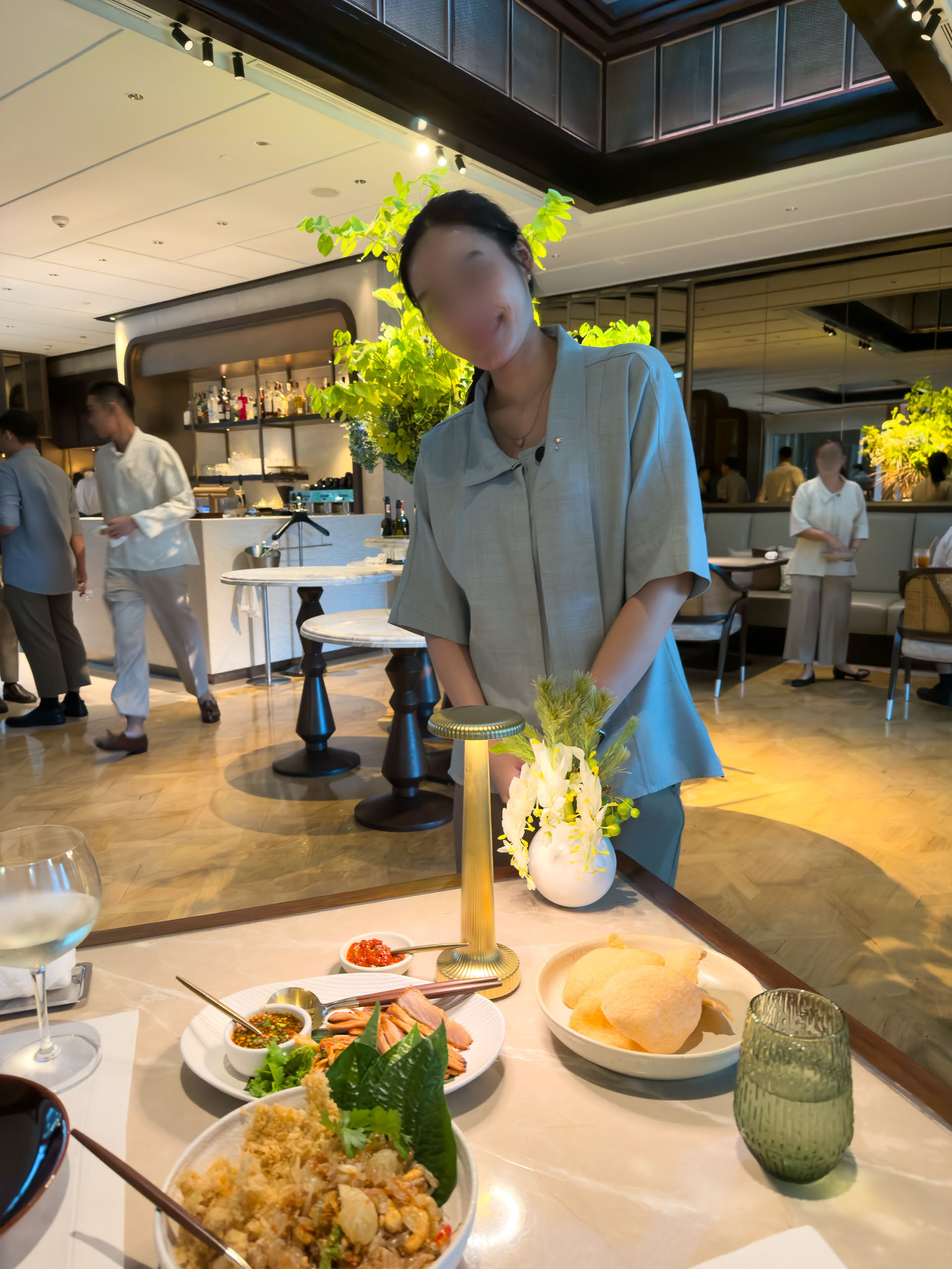 A table of Thai dishes at the open counter, the kitchen team working behind