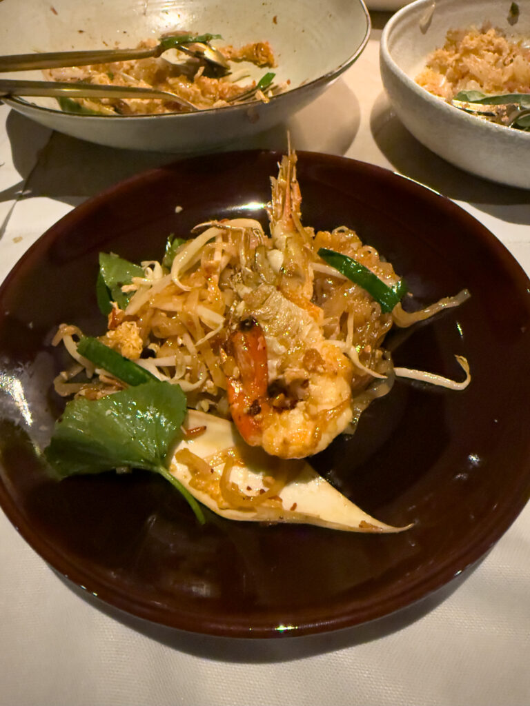 Bowls of noodles and rice set out together on a dark table