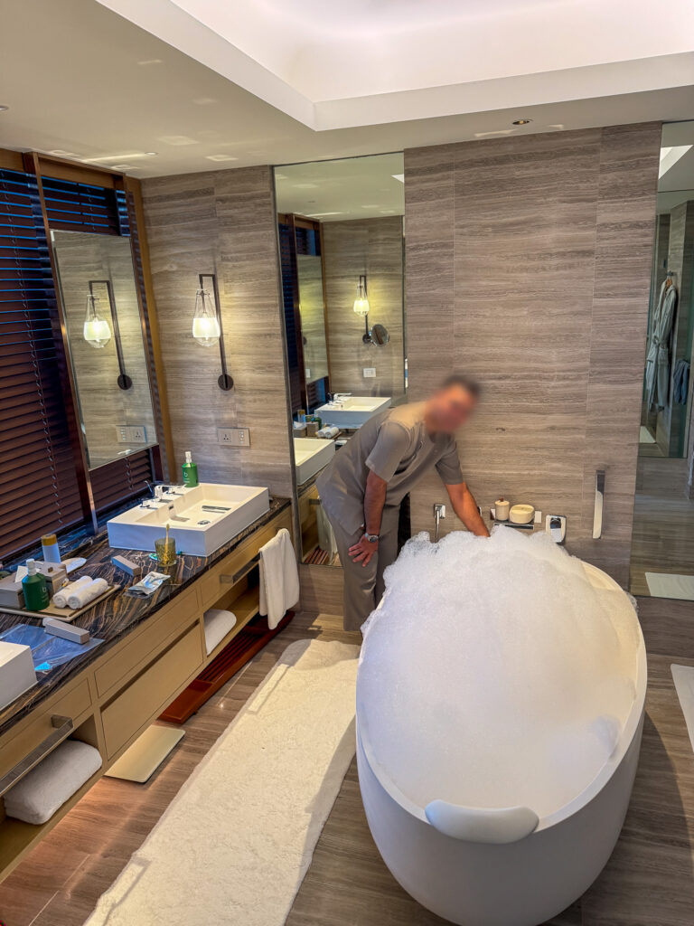 A bath being drawn, petals scattered on the water