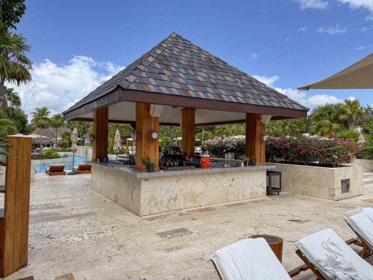 The thatched pool bar with towels stacked on its counter