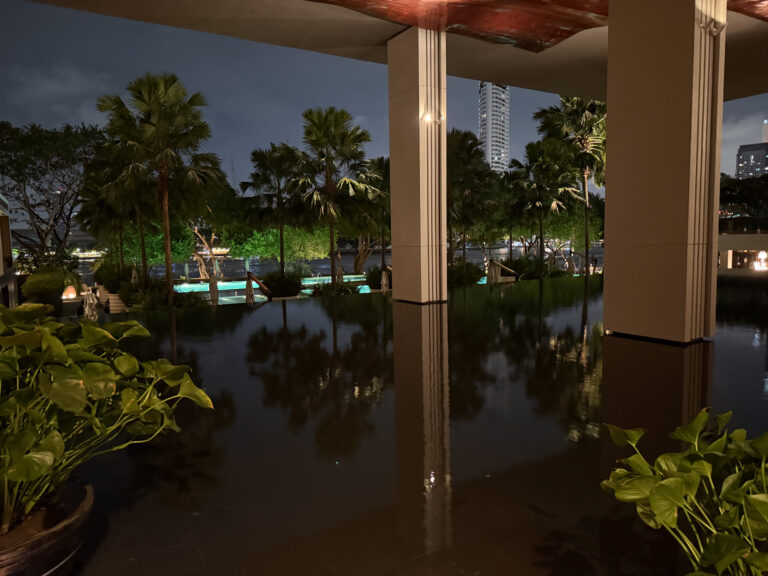 The reflecting pool between the colonnades at night, palms mirrored in the still water