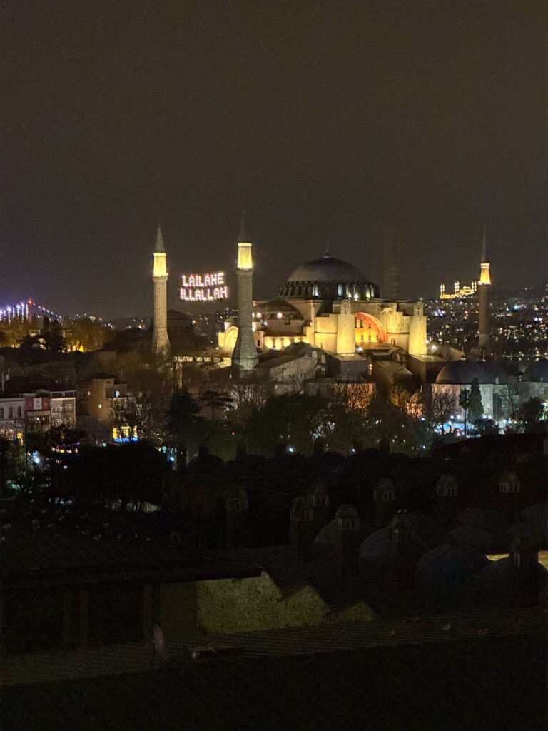 Hagia Sophia and the Blue Mosque lit above the dark gardens between them