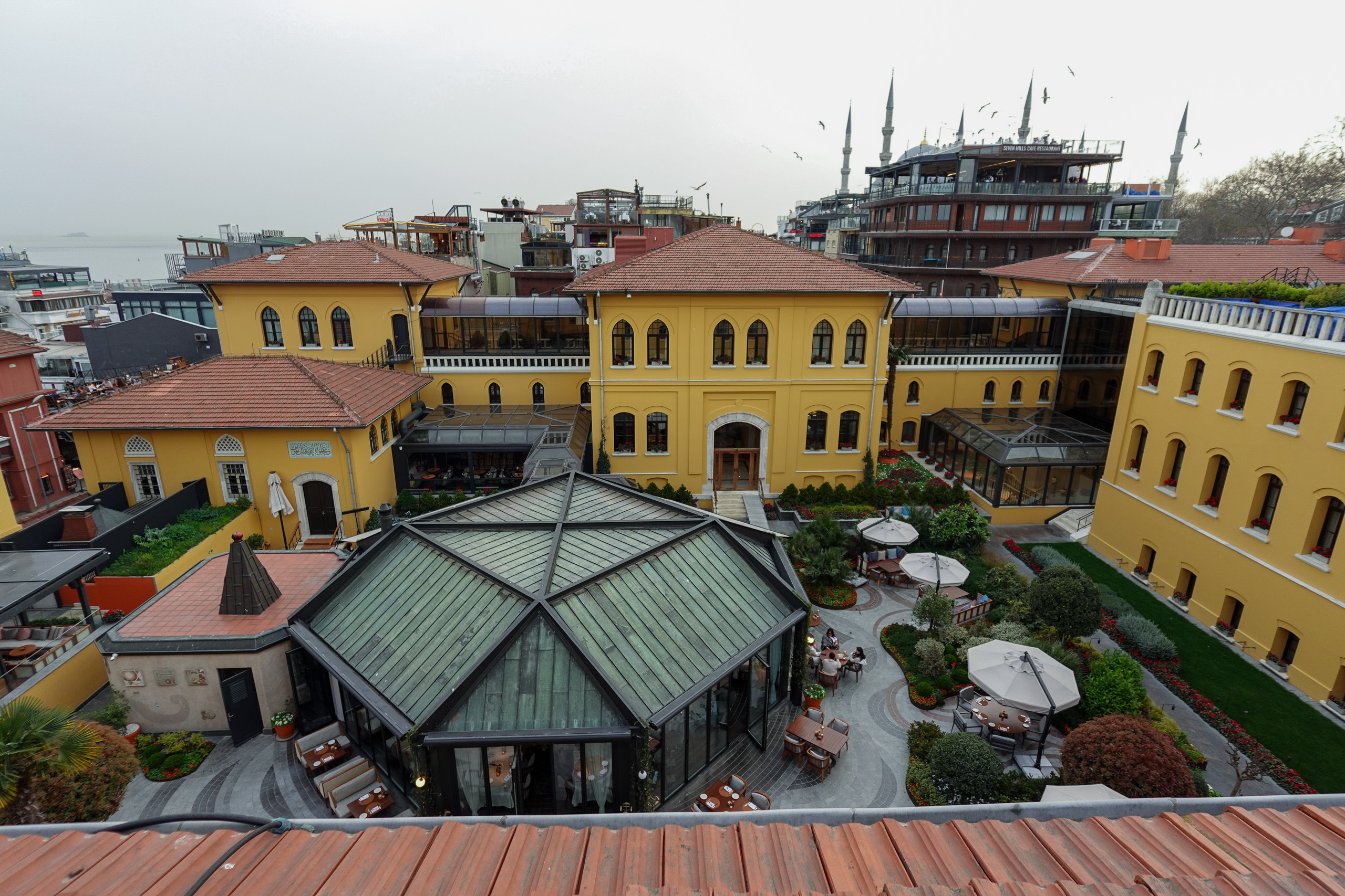 Looking down into the courtyard, its glazed pavilion set among the ochre wings