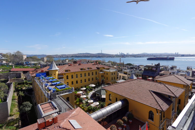 Daylight over the rooftops of the old town, with shipping on the water beyond