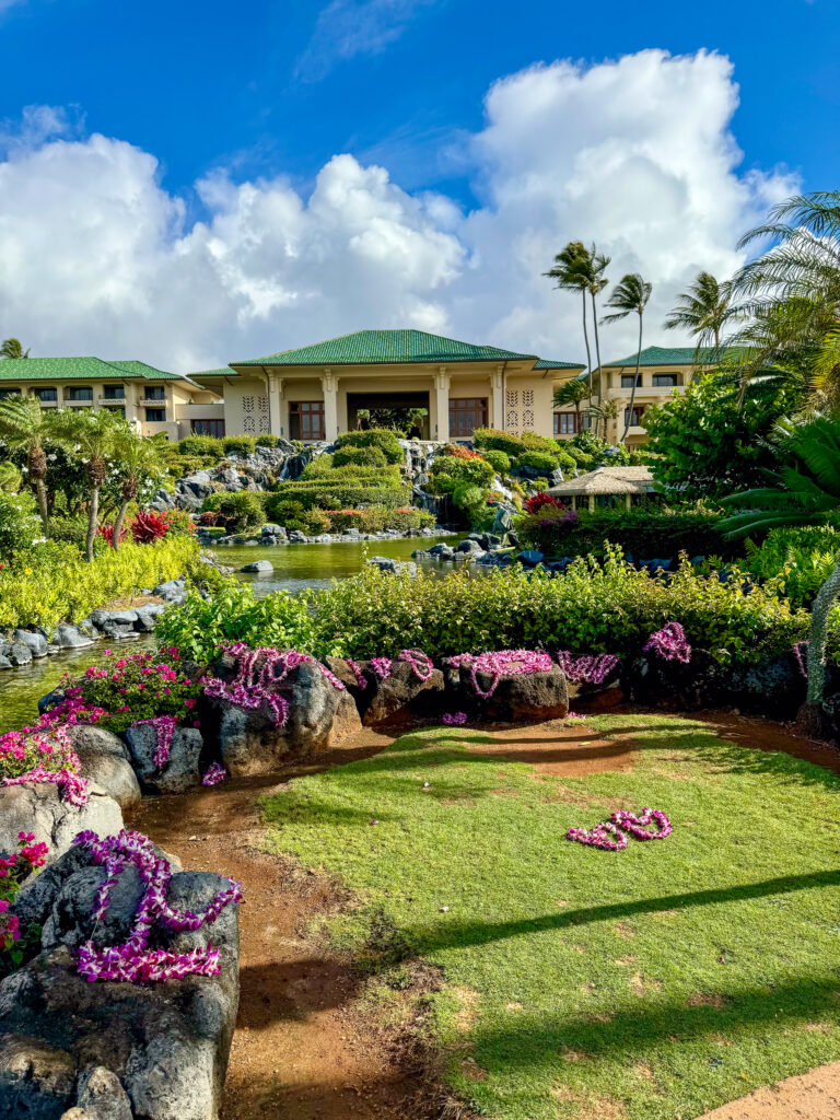 Clipped lawn and flowering shrubs between the low wings of the hotel