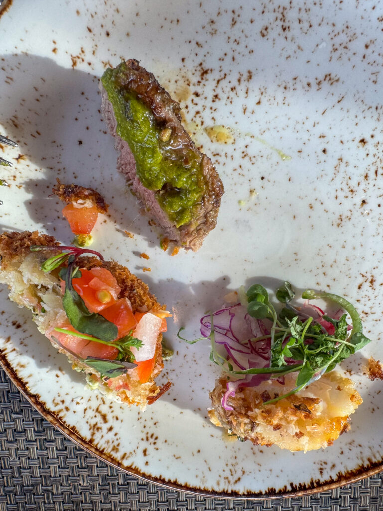 A dish of raw fish and avocado, dressed and dusted, on a white plate