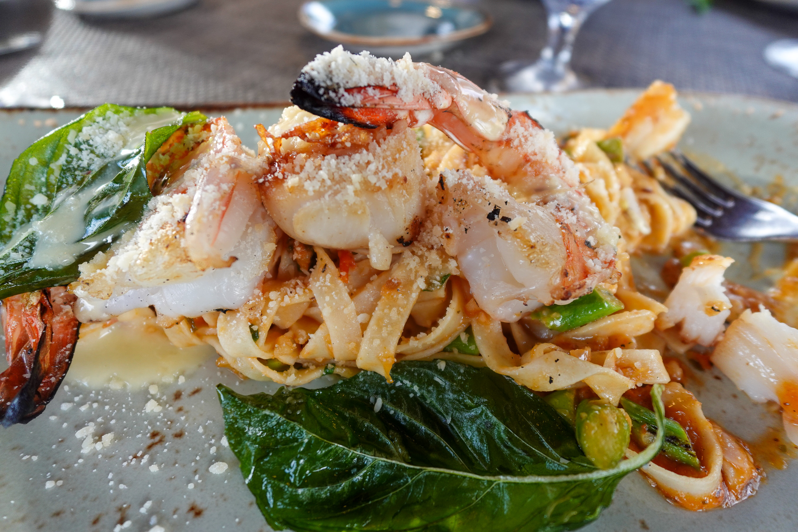 Prawns and greens piled on the plate, the shells left on
