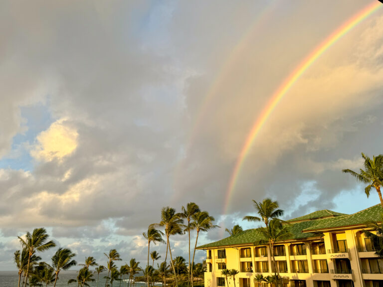 A rainbow standing over the hotel's yellow buildings after rain