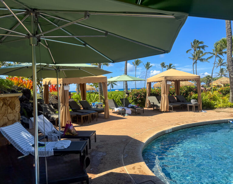 Loungers and canvas umbrellas set out around the pool