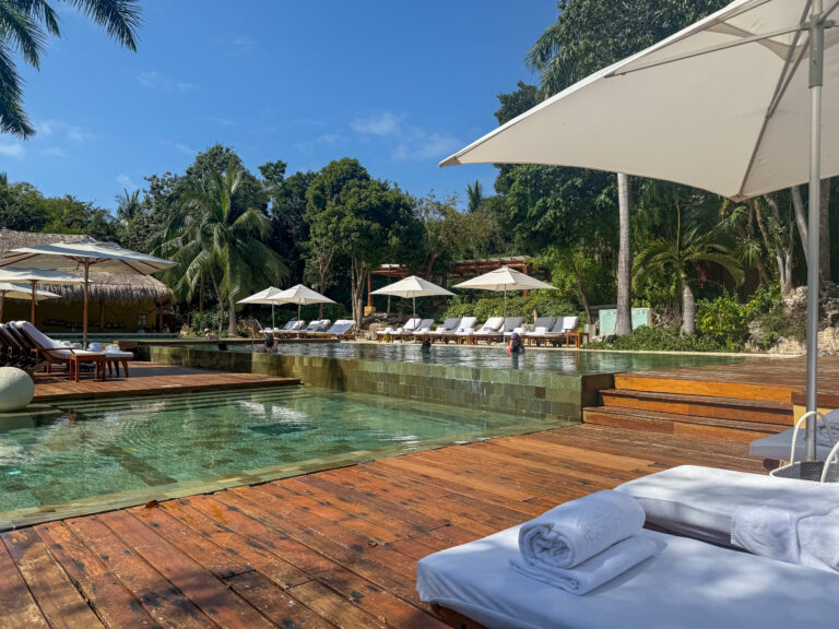 A daybed and umbrella on the pool deck