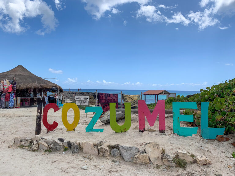 The painted letters spelling out the island's name, a thatched bar behind them