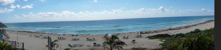 The beach and the water stretching away under a wide flat sky