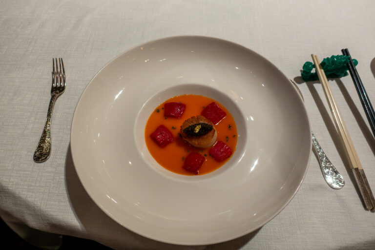 A small course dressed in a red-orange sauce