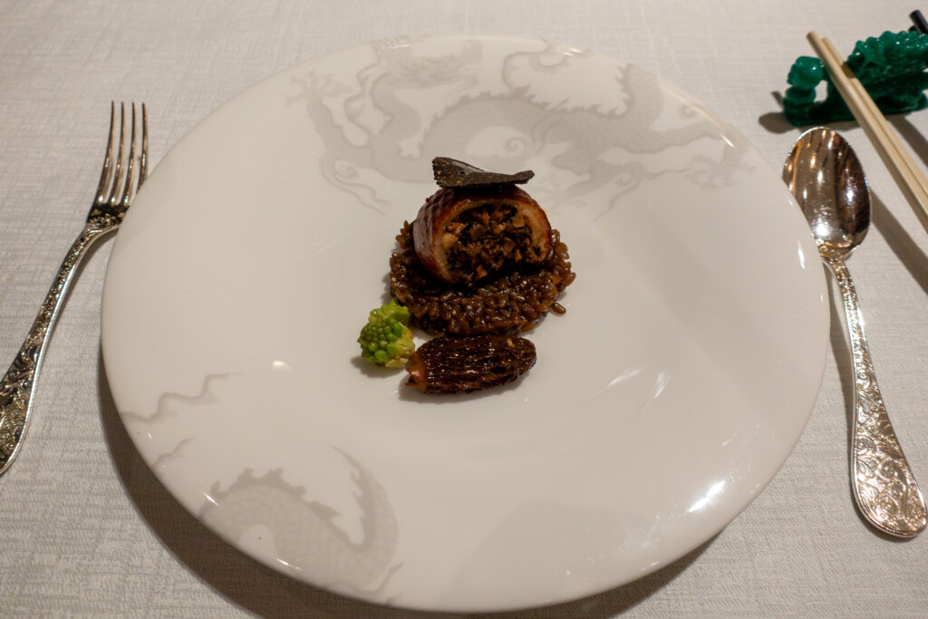 A dark crisp pastry nest set alone on a dragon-relief plate