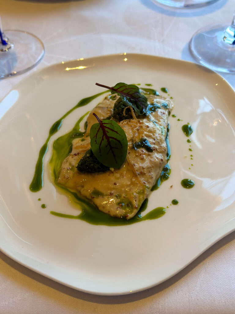 A plated course under green herb oil at Tuğra