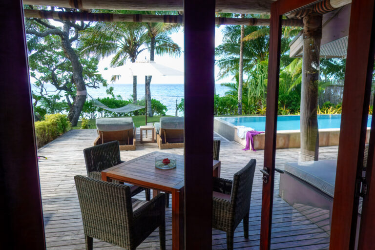 The table on the deck, the pool and the water beyond