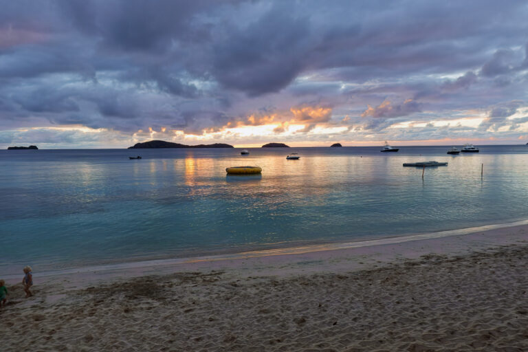 Boats moored off the beach at sunset