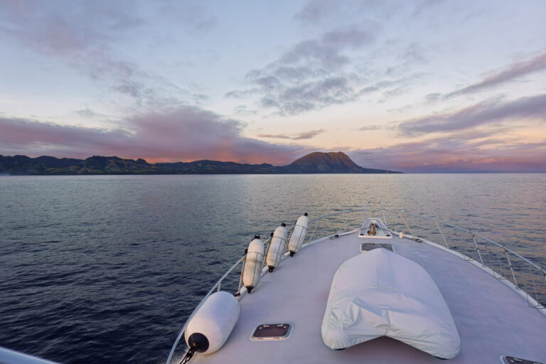 Flat water and the island ridge seen from the bow at first light