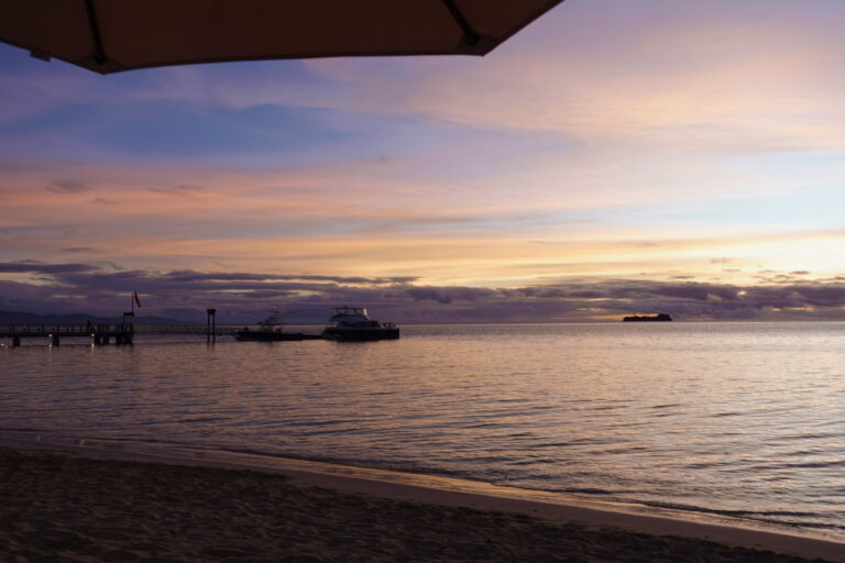 Boats at anchor off the beach at dusk