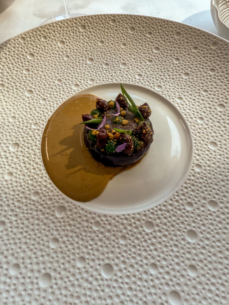 A dark course sitting in a yellow sauce