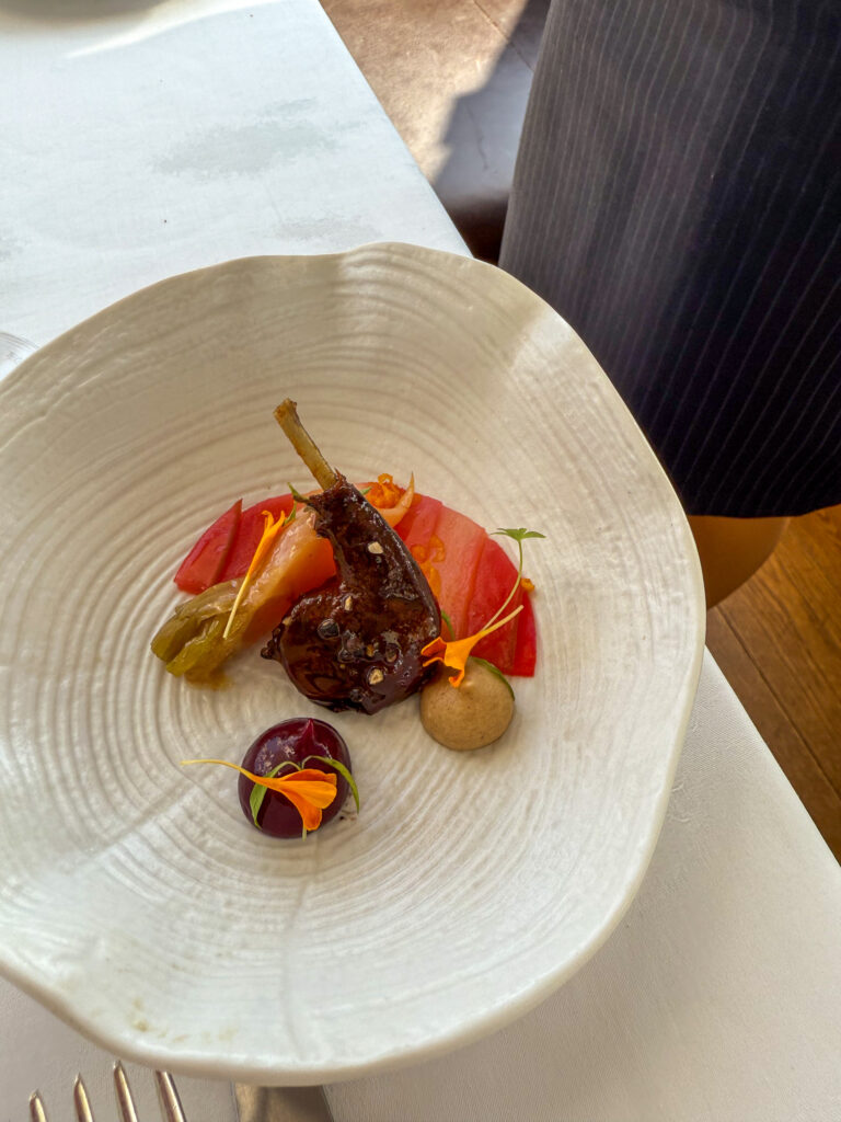 A dark fig-like element with peach slices and a green olive