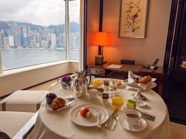 Breakfast laid on a round table at the window, the harbour beyond