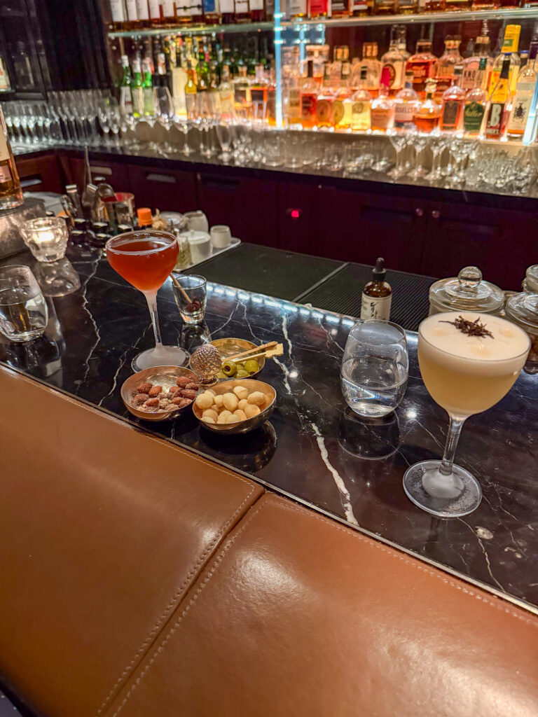 Cocktails and a bowl of snacks on the marble bar counter
