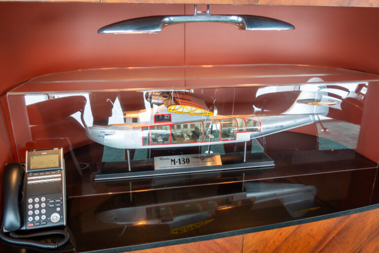 A cased model of a Martin M-130 flying boat above the desk