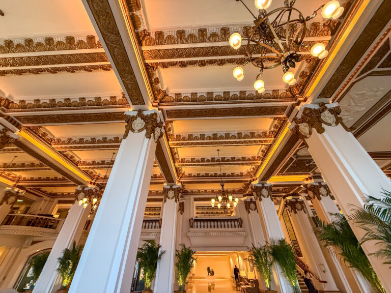 The gilded coffered ceiling and columns of the lobby from below