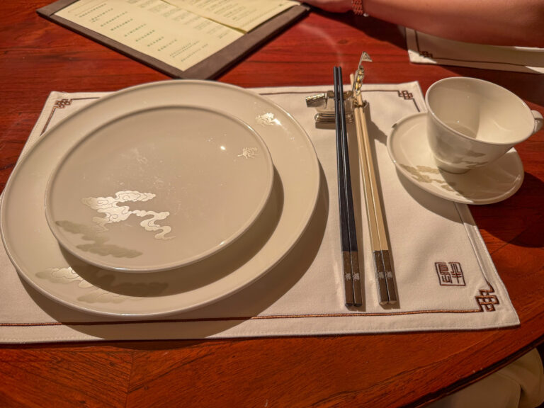 A place setting of chopsticks and porcelain on a red lacquer table