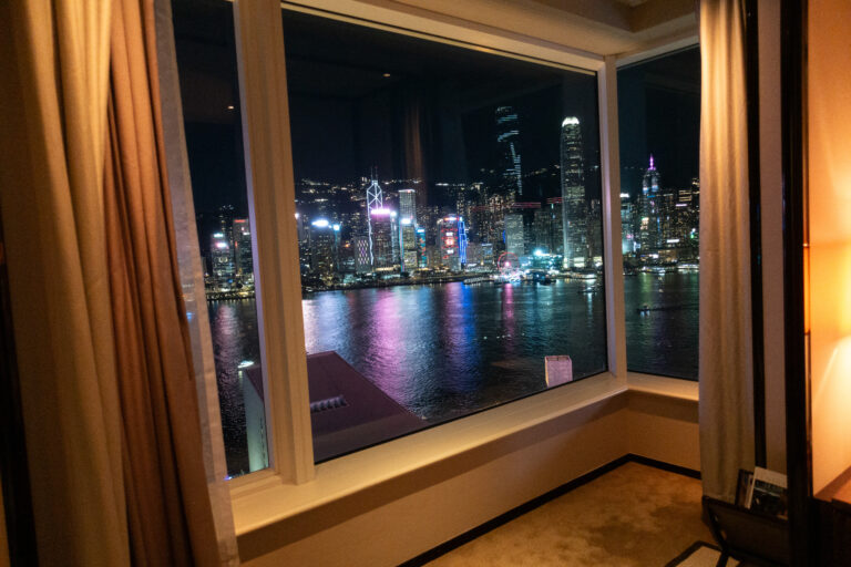 The harbour at night framed by the curtains of the darkened room