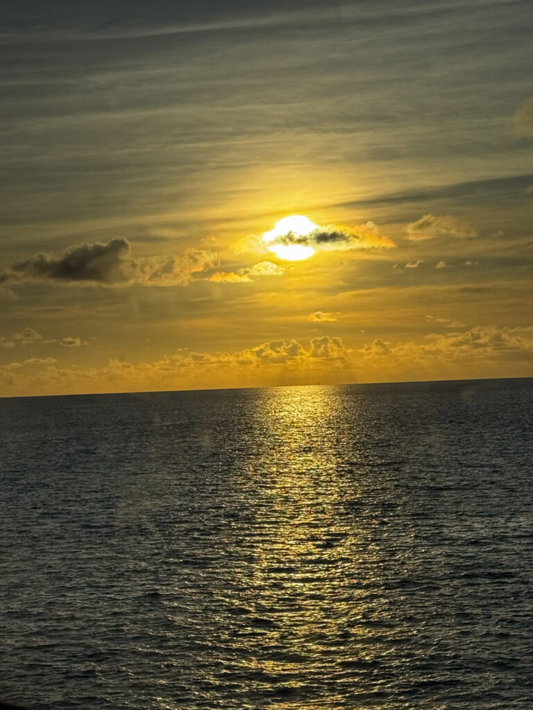 The sun dropping to the horizon, a track of light across the sea