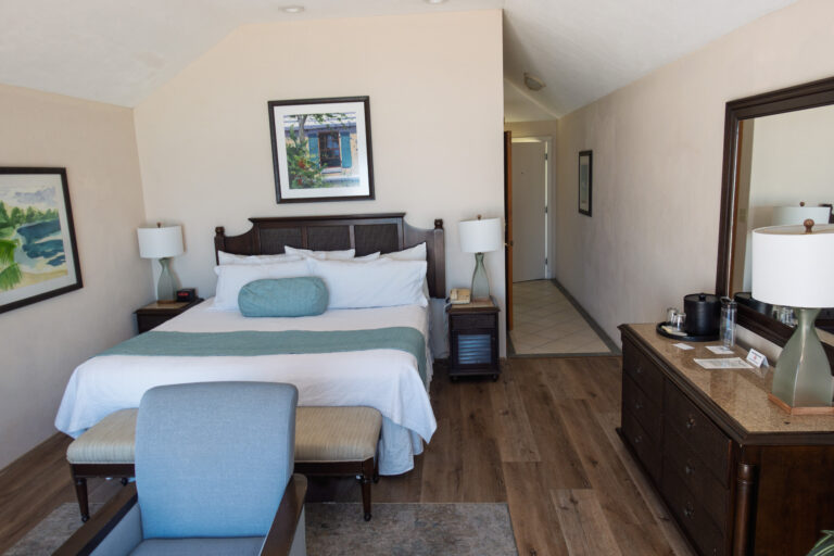 A guest room with a blue armchair by the window