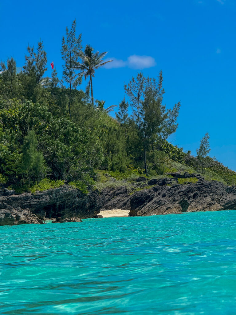 A small boat moored off a wooded point in bright turquoise water