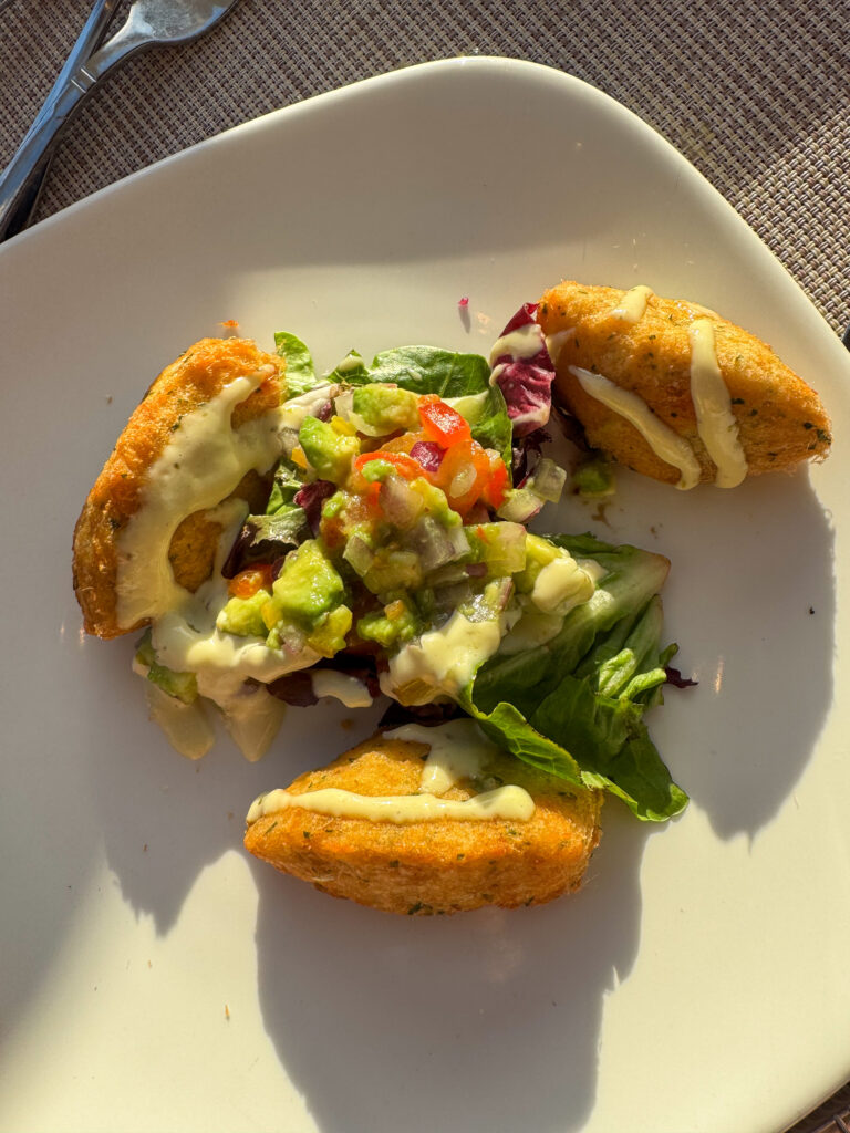 Fish and avocado plated with a wedge of citrus