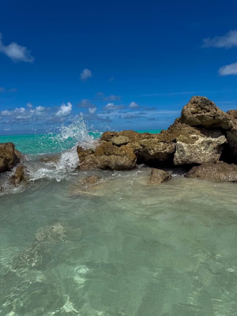 Weathered rock standing in the shallows off the beach